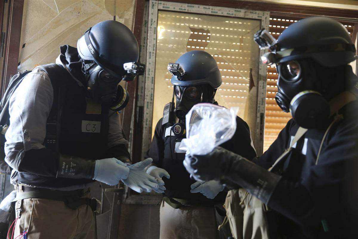 A U.N. chemical weapons expert holds a plastic bag containing samples from one of the sites of a chemical weapons attack Photo by Mohamed Abdullah