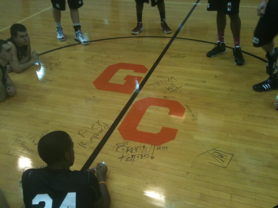 The players sign the court to symbolize how they will take responsibility for what happens on their floor. Media by Greenville College Men's Basketball @facebook.com
