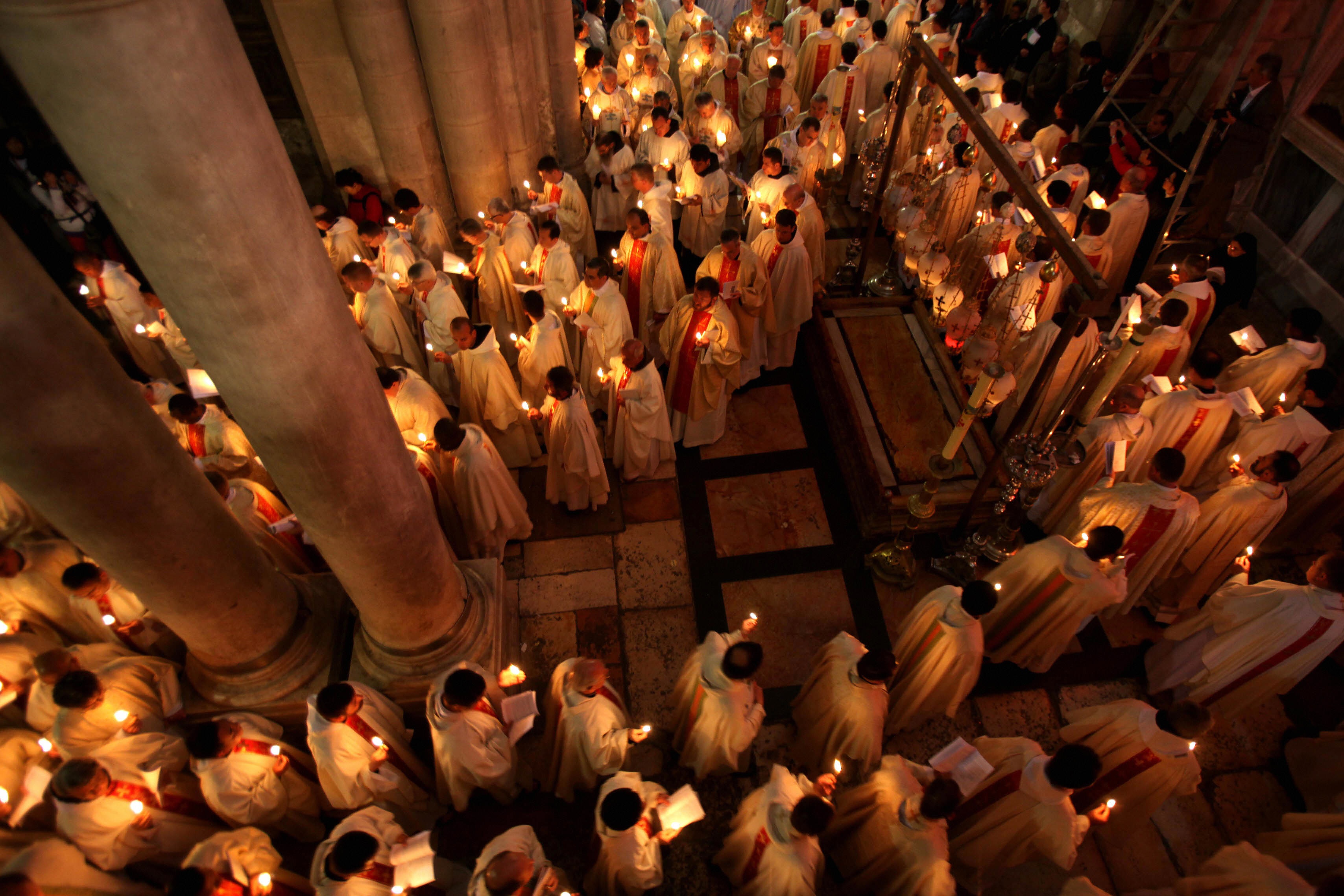 Roman Catholic clergy men hold candles as they circle the aedicule on Holy Thursday. Many Christians believe that  the Church of the Holy Sepulchre in Jerusalem is where Jesus was crucified and buried. Source:http://www.cnn.com