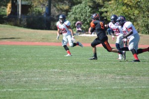 Jacob Battaglia tries to evade a couple defenders. Photo from Greenville College Football