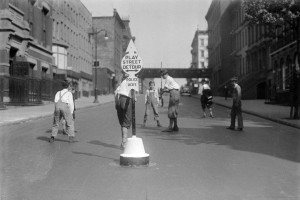 A picture of kids in the streets of New York City playing stickball. In many ways, the game is very similar to baseball. Lombardi's father organized games with neighbors for him during his childhood. 