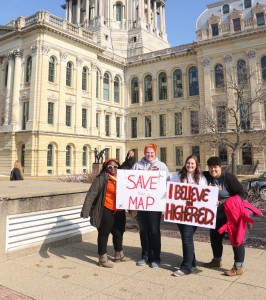 Four students hold up sign to save the MAP grant