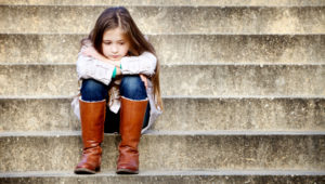Little girl sitting on steps, sad